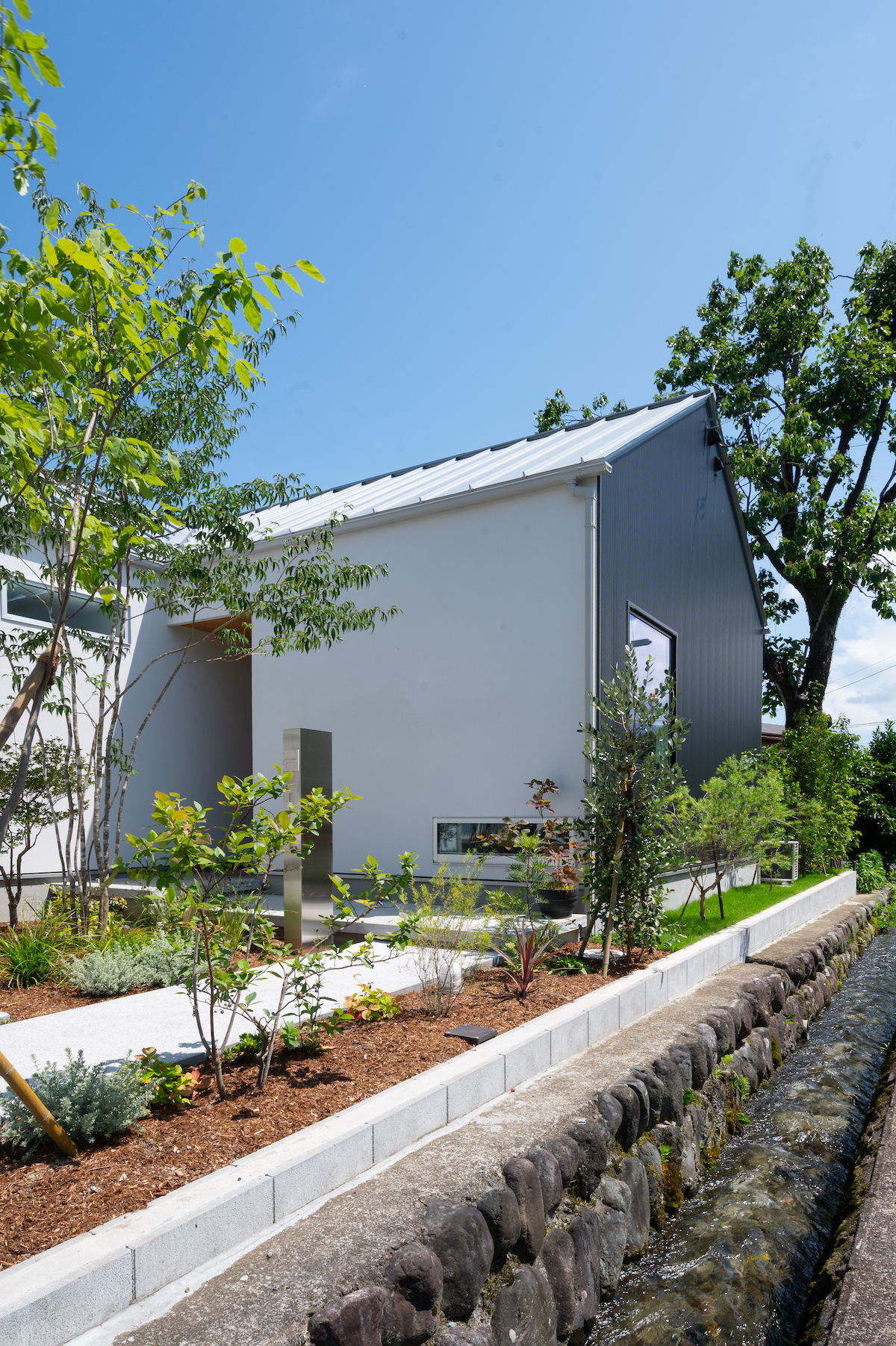 開成町の住まい｜庭の緑に佇む、白い切妻屋根の平屋の外観｜中川工務店の建築家設計の注文住宅