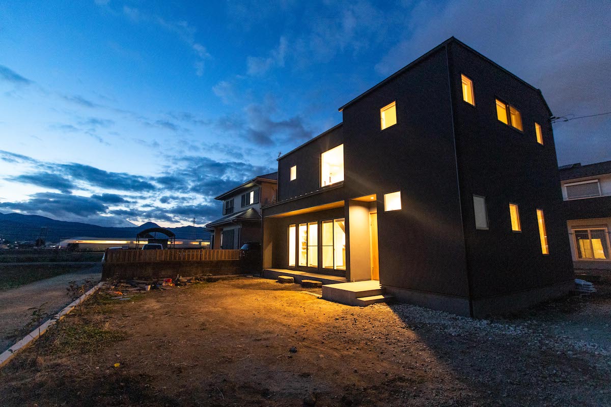 小田原市の住まい｜夕景の外観、窓から漏れる温かい光